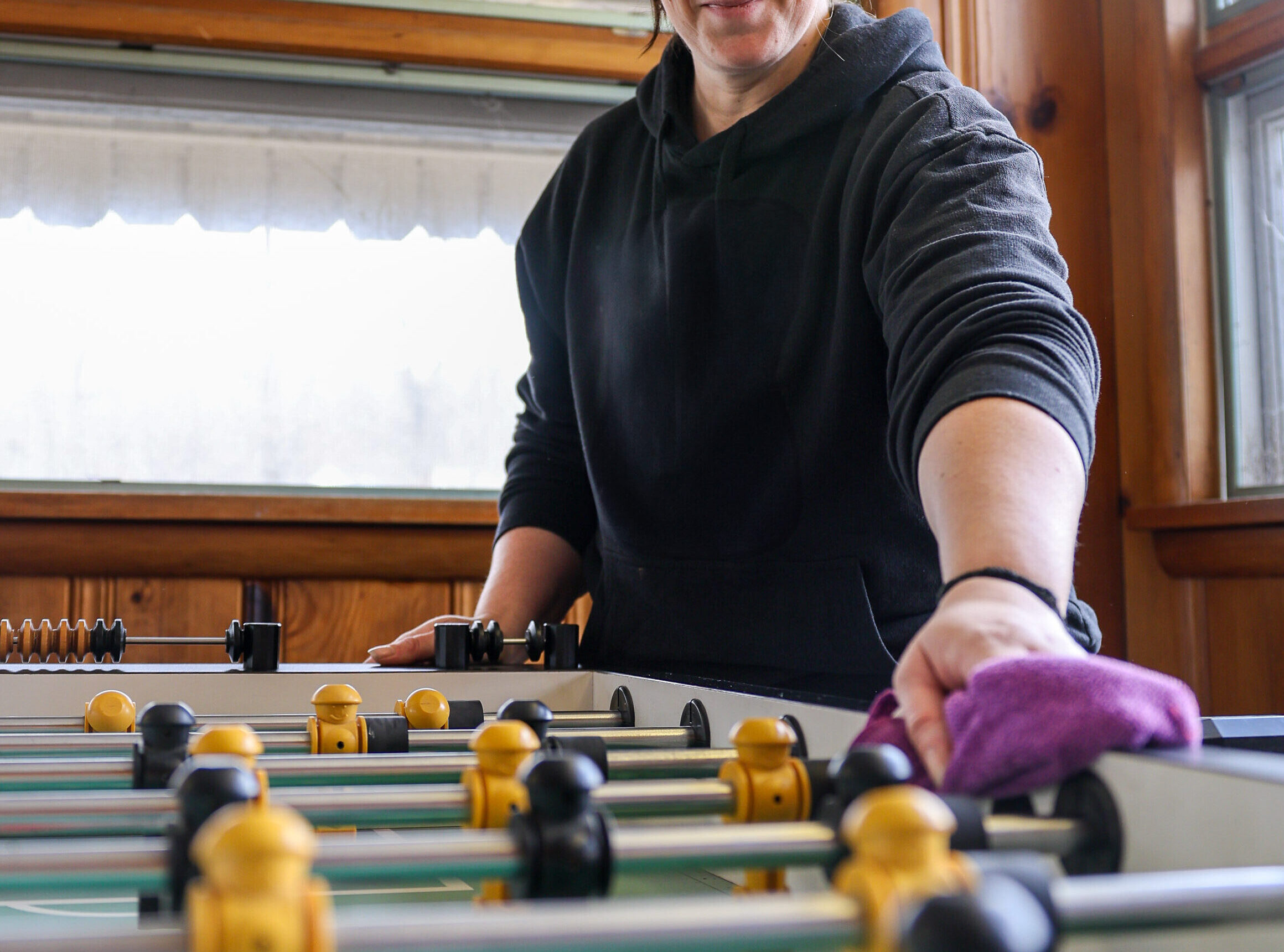 A Brightridge Cleaning professional carefully wiping down a table in a residential home, demonstrating their attention to detail and commitment to carpet cleaning and soft washing services.